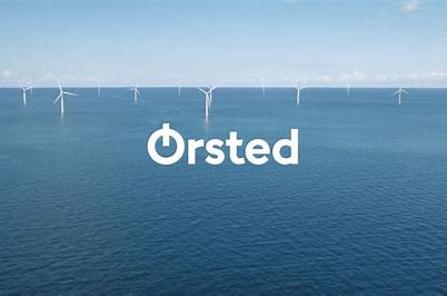 Orsted logo over a wind turbine plant in the sea