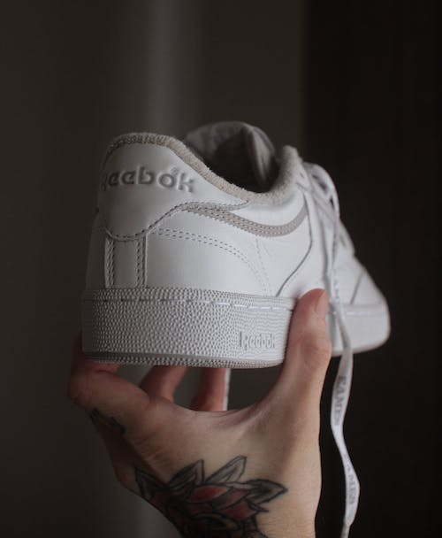 person holding white keds