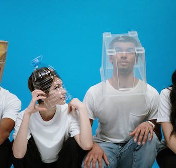 four person sitting wearing plastic and paper packages