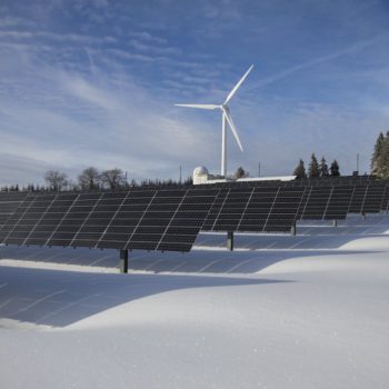 wind turbine and solar panels in a ice covered area