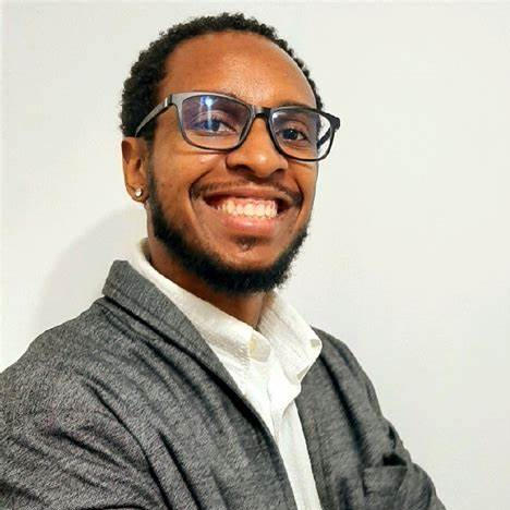 black male person smiling and posing for portrait photo